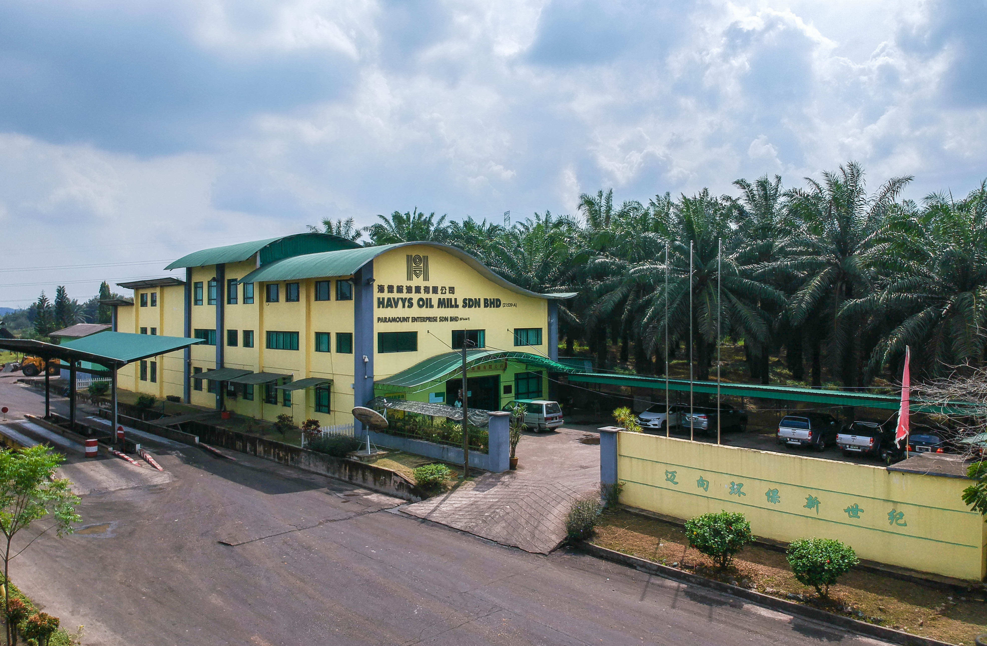 The yellow and green Havys Oil Mill office surrounded by oil palms in Mukim Bera, Pahang